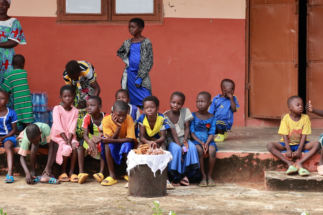children-sitting-together-outside-a-building-wtlpwnlibes