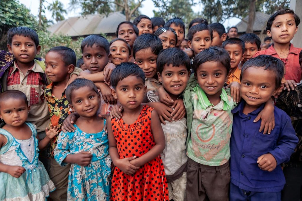 group-of-smiling-children-standing-closely-together-outdoors-pmxc4wv97d0